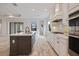 Modern kitchen with stainless steel appliances, an island with a sink, and white cabinets at 26833 Weiskopf Dr, Englewood, FL 34223