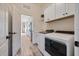 Bright laundry room features wood-look tile, white cabinets, sink, washer and dryer, and a passthrough to the kitchen at 26833 Weiskopf Dr, Englewood, FL 34223