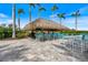 Outdoor bar with a thatched roof, offering a casual gathering spot for friends or neighbors at 26833 Weiskopf Dr, Englewood, FL 34223