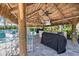Outdoor kitchen features a tiki hut, bar seating, two ceiling fans, a grill, and views of the property at 26833 Weiskopf Dr, Englewood, FL 34223