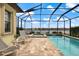 Screened-in lanai showcasing a pool and spa with a picturesque view of the lake at 26833 Weiskopf Dr, Englewood, FL 34223