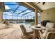 Outdoor screened lanai with a pool, spa, and comfortable seating area overlooking the water at 26833 Weiskopf Dr, Englewood, FL 34223
