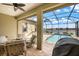 A screened lanai with view of a pool, spa, and waterfront, furnished with outdoor seating at 26833 Weiskopf Dr, Englewood, FL 34223