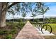 Outdoor view of tennis courts over a red bricked walkway and bike racks on each side at 26833 Weiskopf Dr, Englewood, FL 34223