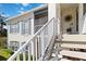 Two-story condo building showcasing white trim, sunny entryway, and charming blue shutters, creating a cozy, inviting appeal at 306 Lynbrook Cir # 201, Venice, FL 34292