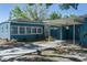 A delightful blue home with a covered parking area and a friendly cat sitting nearby at 3200 Avenue A W, Bradenton, FL 34205