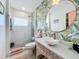 Bathroom showcasing a modern vanity, round mirror, and a glass-enclosed shower at 3228 Webber St, Sarasota, FL 34239