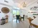 The dining area features stylish chairs, a modern light fixture, and sliding glass doors to the lanai at 3228 Webber St, Sarasota, FL 34239