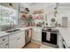 Bright kitchen featuring stainless steel appliances, white cabinets, quartz countertop, and modern backsplash at 3228 Webber St, Sarasota, FL 34239