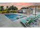 Relaxing poolside view featuring lounge chairs, manicured landscaping and a modern sunroom at 3228 Webber St, Sarasota, FL 34239
