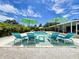Inviting pool area with lounge chairs, umbrellas, and beautiful landscaping at 3228 Webber St, Sarasota, FL 34239