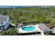 Community pool with lounge chairs surrounded by a manicured landscape and tropical foliage at 3316 10Th W Ln, Palmetto, FL 34221