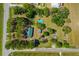 Aerial view shows house with pool surrounded by lush green trees and vast land at 34200 State Road 62, Parrish, FL 34219