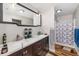 Bathroom features double sinks, large mirror, and shower with patterned curtain at 34200 State Road 62, Parrish, FL 34219