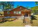 Exterior front view of home featuring wood siding, front porch, steps and lawn at 34200 State Road 62, Parrish, FL 34219