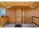 Charming covered front porch showcasing a wood-paneled exterior and decorative front door at 34200 State Road 62, Parrish, FL 34219