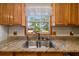 A sunlit kitchen sink with wooden cabinets and a view to the backyard at 34200 State Road 62, Parrish, FL 34219