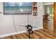 A comfortable living room featuring wood flooring, a mounted television, and a view into the dining room at 34200 State Road 62, Parrish, FL 34219