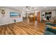 Large living room with wood flooring leading to a kitchen, dining area, and a mounted television at 34200 State Road 62, Parrish, FL 34219