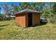 Exterior shot of a brown wooden shed structure with an open entrance on an overgrown lot at 34200 State Road 62, Parrish, FL 34219