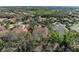 An aerial view showcases the neighborhood with lush greenery and tile roofs at 3751 Eagle Hammock Dr, Sarasota, FL 34240