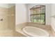 Bright bathroom features a soaking tub, a shower, and a window with natural light at 3751 Eagle Hammock Dr, Sarasota, FL 34240