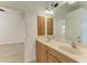 Bright bathroom features a double vanity, a view into the primary bedroom, and tile flooring at 3751 Eagle Hammock Dr, Sarasota, FL 34240