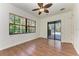 A bright bedroom with wood flooring, ceiling fan and sliding glass doors to outdoor pool area at 3751 Eagle Hammock Dr, Sarasota, FL 34240