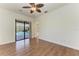 A bright bedroom with wood flooring, ceiling fan and sliding glass doors to outdoor pool area at 3751 Eagle Hammock Dr, Sarasota, FL 34240