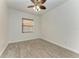 A bright bedroom with wood-look tile flooring, ceiling fan and natural light from the window at 3751 Eagle Hammock Dr, Sarasota, FL 34240