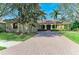 Charming home with a brick driveway, arched entryway, and lush landscaping creates an inviting curb appeal at 3751 Eagle Hammock Dr, Sarasota, FL 34240