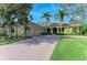 Home featuring a brick driveway, well-manicured lawn, and a classic architectural style exudes timeless elegance at 3751 Eagle Hammock Dr, Sarasota, FL 34240
