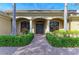 A home's entrance is framed by columns, manicured hedges, and a brick walkway, creating an inviting pathway at 3751 Eagle Hammock Dr, Sarasota, FL 34240
