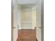 Hallway with hardwood flooring, white doors, and arched doorway, providing clear view of the next room at 3751 Eagle Hammock Dr, Sarasota, FL 34240