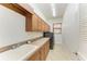 Functional laundry room with wood cabinets, sink, countertop, a window and a washer and dryer at 3751 Eagle Hammock Dr, Sarasota, FL 34240