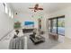 Staged living room with tile flooring, ceiling fan and sliding glass doors to a screened pool at 3751 Eagle Hammock Dr, Sarasota, FL 34240