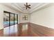 Large main bedroom with tray ceiling, ceiling fan, and glass door leading to a pool at 3751 Eagle Hammock Dr, Sarasota, FL 34240