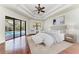 Well-lit main bedroom features a tray ceiling, ceiling fan, and glass door to pool area at 3751 Eagle Hammock Dr, Sarasota, FL 34240