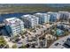 Aerial view of condo buildings, pool, and recreation areas near the bay with the community's landscaped roadways at 383 Aruba Cir # 102, Bradenton, FL 34209