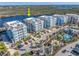 Aerial view of condo buildings by the bay, with a community pool and recreation area with tiki umbrellas at 383 Aruba Cir # 102, Bradenton, FL 34209