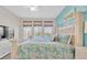 Bedroom with waterfront view, bamboo shades, and blue accent wall at 383 Aruba Cir # 102, Bradenton, FL 34209