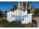 Community signage at One Particular Harbour Margaritaville at Marina Walk, near lush landscaping and condo buildings at 383 Aruba Cir # 102, Bradenton, FL 34209