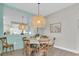 Dining area with round table, wood chairs, and unique woven pendant light at 383 Aruba Cir # 102, Bradenton, FL 34209