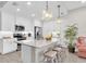 Bright kitchen featuring granite counters, stainless appliances, white cabinets, pendant lighting, and seating at the island at 383 Aruba Cir # 102, Bradenton, FL 34209