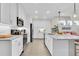 Modern kitchen with island, white cabinets, stainless appliances, and wood-look tile flooring at 383 Aruba Cir # 102, Bradenton, FL 34209