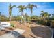 Community playground with green metal climbing equipment, a slide, a bench, and perimeter landscaping at 383 Aruba Cir # 102, Bradenton, FL 34209
