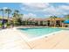 Community pool surrounded by a black metal fence, lounge chairs and views of condos beyond at 4008 Crockers Lake Blvd # 13, Sarasota, FL 34238