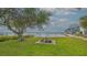 Waterfront property with a shaded seating area near the water's edge and mature trees at 4011 11Th Street W Ct, Palmetto, FL 34221