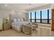 Serene main bedroom with ocean views, neutral decor, and sitting area with chairs at 415 L Ambiance Dr # D606, Longboat Key, FL 34228