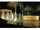 Nighttime view of a water feature and signage at L'Ambiance community, surrounded by palm trees at 415 L Ambiance Dr # D606, Longboat Key, FL 34228